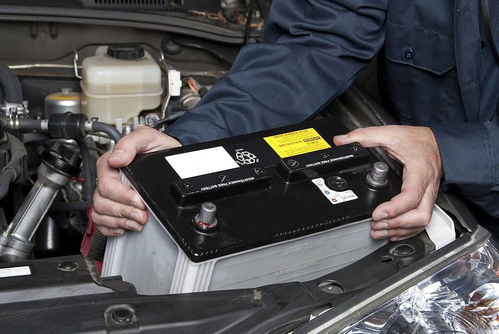 Auto mechanic replacing car batteries